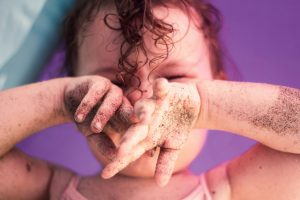 facteurs aggravants eczéma infantile bébé avec du sable sur les mains