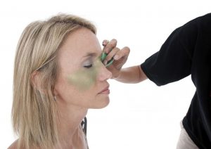 Application par tapotements d'un correcteur vert pour neutraliser les rougeurs cutanées